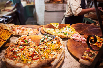 Italian, street restaurant preparing pizza with various toppings &ndash; outdoor dining