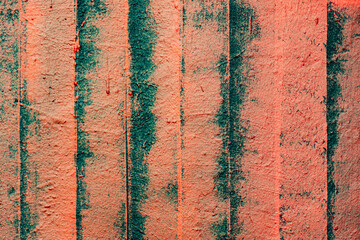 A wall displays vibrant vertical stripes in orange and teal, creating a striking visual contrast...