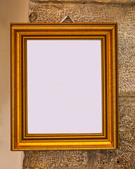 Empty bronze coloured metal frame hanging on a wall interior