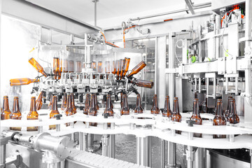 Process pasteurization Brown glasses bottles with beer, moving on conveyor. Concept production line...