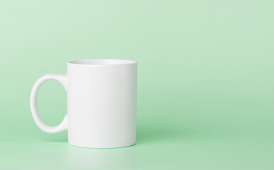 white cup for tea or coffee on a green background