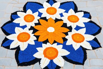 Colorful Pookalam design reflecting tradition in a temple courtyard during the Onam celebration