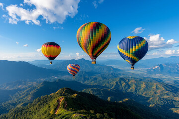 Obraz premium Colorful hot air balloons floating above scenic mountains under a bright blue sky, capturing adventure and freedom.