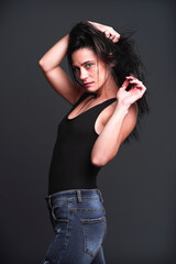 Model striking a confident pose in front of a dark background during a photoshoot