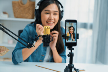 Host channel Asian influencer talking in broadcast wearing headsets on social media live on...