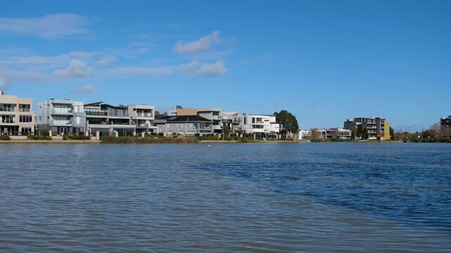 A row of modern luxury waterfront homes or residential properties at Caroline Springs Lake, suburban living with a beautiful environment in Melbourne Australia.
