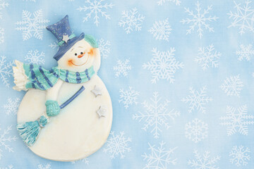 Snowman on snowflake pattern on light blue background