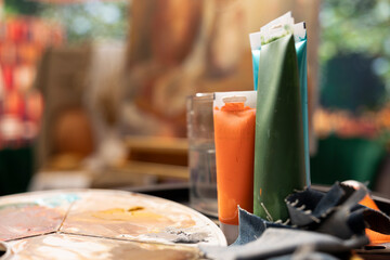 Modern paintwork supplies and coloring tubes or oil paints in creative atelier, brush kit and colorful pigments used for masterpiece creation art and craft hobby in empty workshop. Close up.