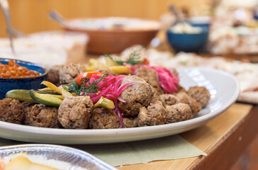 Platter of delicious meatballs with pickled vegetables and herbs