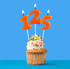 Orange candle number 125 - Birthday cupcake on blue background