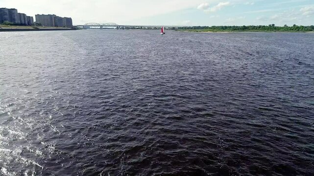Body of water with a red buoy floating on it. The water is dark blue in color. Summer river trips along the Volga River in Nizhny Novgorod, Strelka.