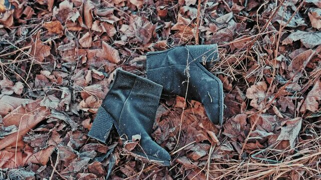 Missing Women Leather Boots Shoes Covered in Morning Hoarfrost Left on Withered Leaves on Cold Morning