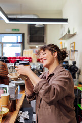 Barista preparing takeaway coffee smiling in a coffee shop