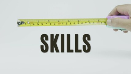 "Skills" text with a yellow tape measure on a white background, symbolizing precision, accuracy, and competency assessment in a clean, minimal video
