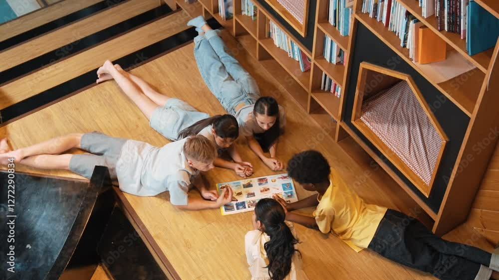 Poster group of diverse children lying down in circle while reading a book at library. top view of girl sha