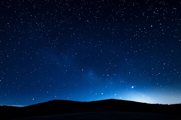Fototapeta premium Dark sky with a few stars and a hill in the background