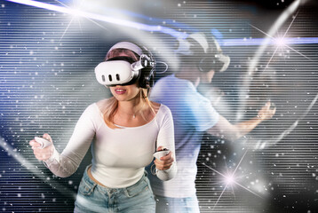 Young couple in VR glasses playing video game against another couple. Friends are enthusiastically...