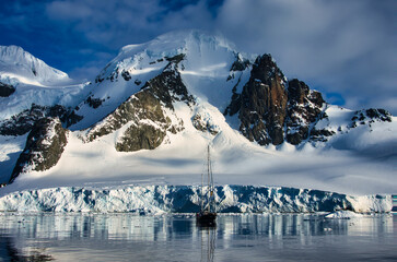 Antarctic Peninsula: Snowy peaks, icebergs, cloudy sky. Lemaire Channel