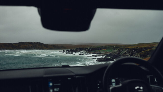 stormy seas viewed from inside a car