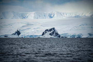 Antarctic Peninsula: Snowy mountains meet icy sea.