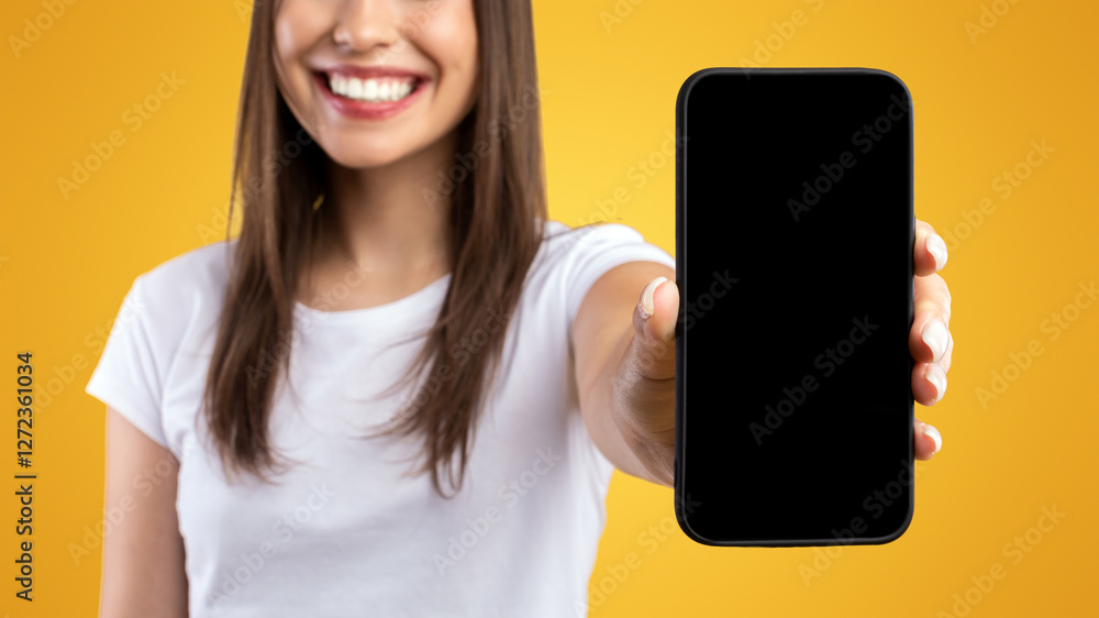 Poster Mobile Application Ad. Portrait Of Happy Lady Showing Smart Phone Black Empty Screen Recommending App Standing Over Yellow Orange Studio Background. Selective Focus On Cell Display, Check This Website