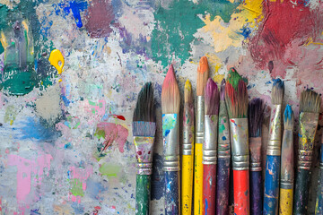 Fototapeta premium Artistic tools of expression, A collection of paintbrushes resting on a vibrant canvas, showcasing the beauty of artistic creation and visual storytelling