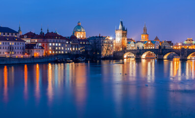 Prague cityscape at twilight featuring Charles Bridge and historic architecture reflecting in the Vltava River, creating a mesmerizing European night view