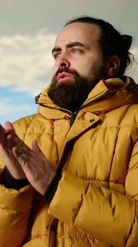 Vertical Video Mountain hiker zipping his jacket after climbing to the top with a vast landscape of peaks and sky, embracing the adventure of trekking through the wilderness. Outdoor exploration