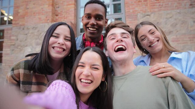 Joyful group of five young friends smiling brightly while posing together for a fun photo, showcasing their happiness and connection in a lively gathering filled with laughter and excitement