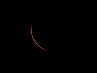 Partial solar eclipse showing moon passing over sun.