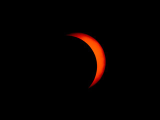 Partial solar eclipse showing moon passing over sun.