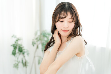 Naklejka premium ビューティ・スキンケア・ヘアケアイメージのノースリーブ姿の笑顔のアジア人女性（悩む・考える） 