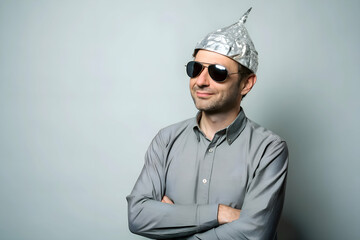 Surreal portrait of a man wearing an aluminum foil hat with sunglasses