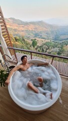Handsome Asian Male Model Relaxing in Bathtub with Stunning Mountain View