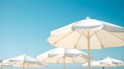 close-up shot of white beach umbrellas against a clear blue sky, space for copy