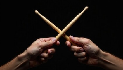 Close-up of crossed drumsticks in hands against black backdrop , isolated, art, roll