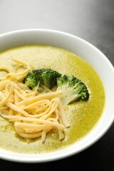 Delicious broccoli cream soup in bowl on gray table, closeup