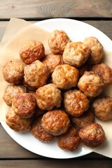 Many delicious meatballs on wooden table, top view