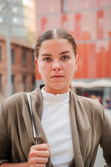 Close up portrait of a Young woman with a serious expression looking directly at the camera while thoughtfully pondering her next steps in an interesting and engaging moment of contemplation