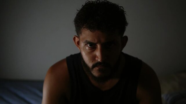 Hispanic man expressing deep thoughts in dark room
