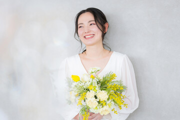 黄色い花束を持つかわいい女性　春や美容、ビューティーイメージ