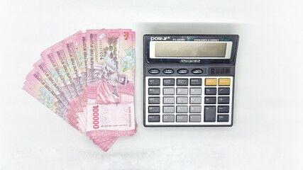 Collection of 100,000 rupiah banknotes and calculator