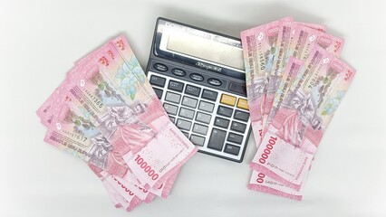 Collection of 100,000 rupiah banknotes and calculator