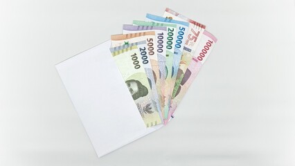 Indonesian banknotes in white envelopes. Collection of banknotes in denominations 1000, 2000, 5000, 10000, 20000, 50000, 75000, 10000 rupiah