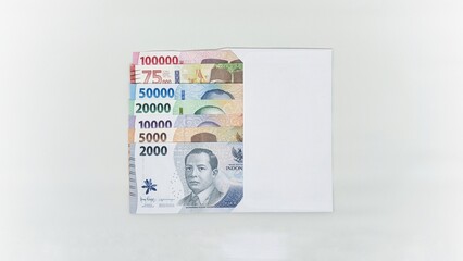 Indonesian banknotes in white envelopes. Collection of banknotes in denominations 1000, 2000, 5000, 10000, 20000, 50000, 75000, 10000 rupiah