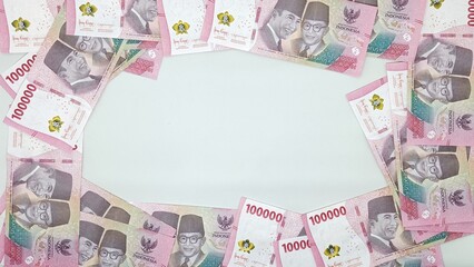 Collection of 100,000 rupiah banknotes are arranged like frame for copy scape. 