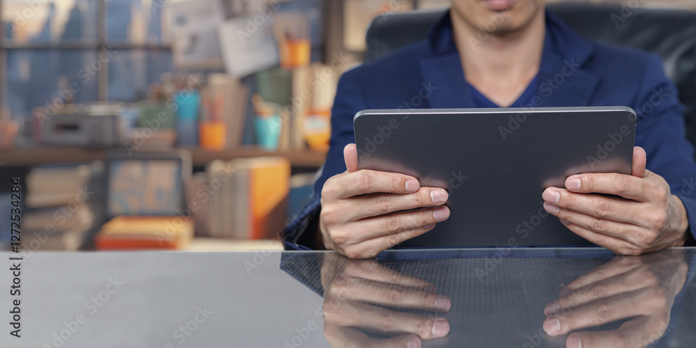 Poster businessman using tablet in modern office setting with reflection
