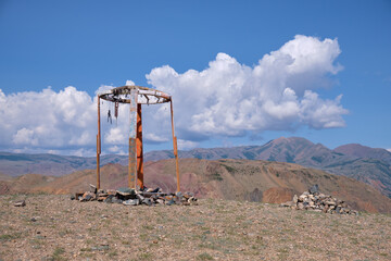Religious wooden construction in Altai mountains. In background Kurai mountain range under blue sky...