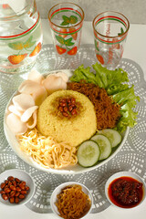 a complete plate of yellow rice which is Indonesian food
