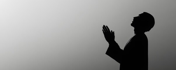 Silhouette of a muslim man praying with hands in supplication
